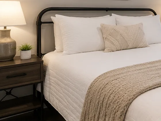 Illustrative image: a freshly made bed in a clean apartment bedroom